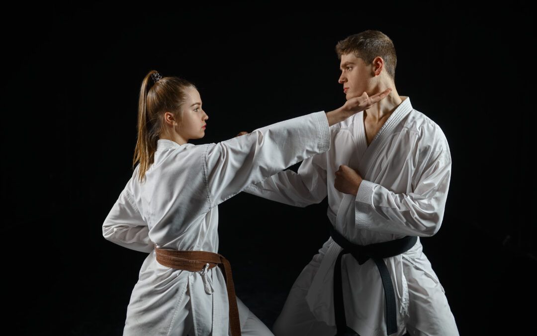 Chica practicante de karate ejecutando un golpe dirigido a un compañero durante un entrenamiento, destacando técnica y agilidad.