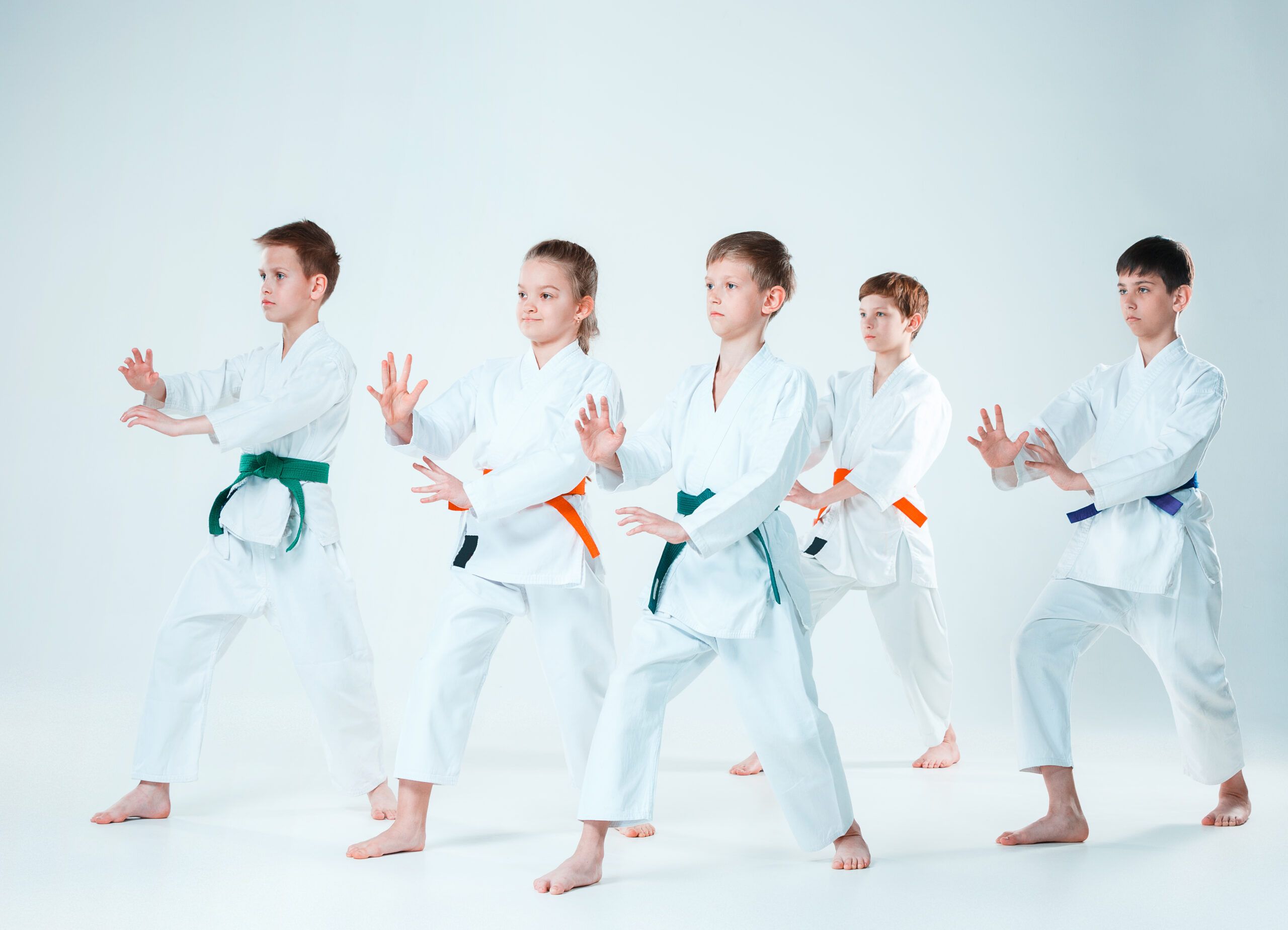Niños practicando katas de karate en grupo, aprendiendo técnica y disciplina en un ambiente motivador.