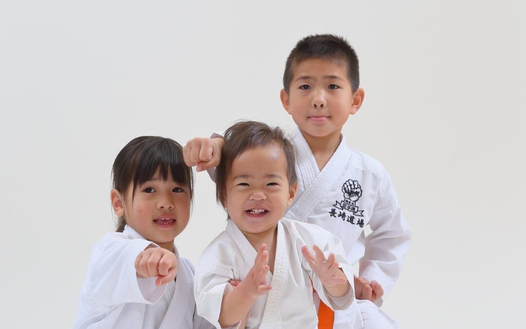 Niños practicando karate en clase, aprendiendo disciplina y coordinación.